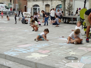 Les enfants dessinent à la craie sur le sol