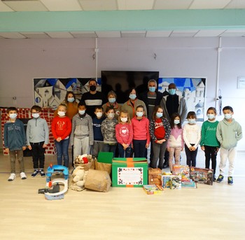 Les enfants et la Croix-rouge avec le résultat de la collecte de jouets