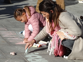 Une enfant et une adulte dessinent à la craie