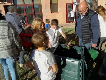 Enfants qui jettent des déchets verts dans le composteur