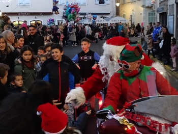 Le Père-Noël distribue des friandises aux enfants lors de la parade de Noël.