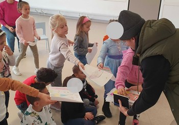 Les enfants montrent leurs dessins à l'artiste