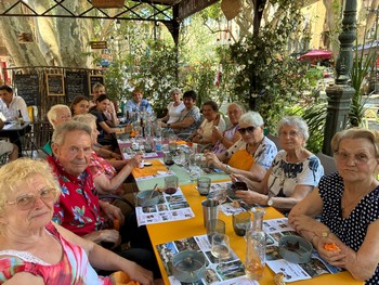 Les personnes agées prennent le déjeuner autour d'une grande table